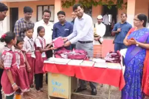 Santhosh of D C BM distributes uniforms to school children