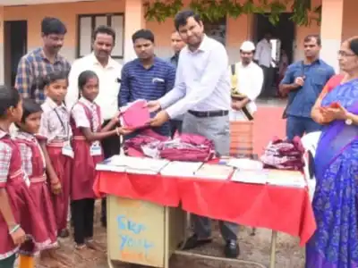 Santhosh of D C BM distributes uniforms to school children